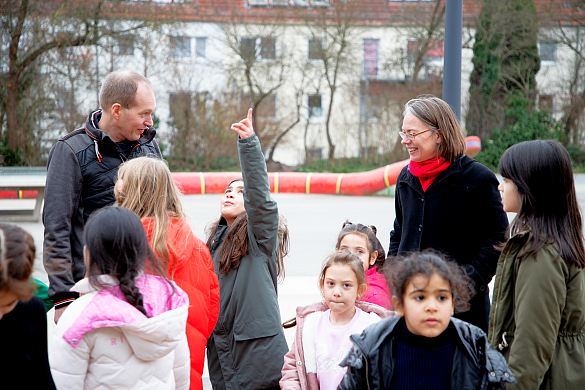 Die Senatorin für Kinder und Bildung, Frau Aulepp, Schulleiter Thomas Murken und einige Kinder im Gespräch auf dem Schulhof am 18.12.2024