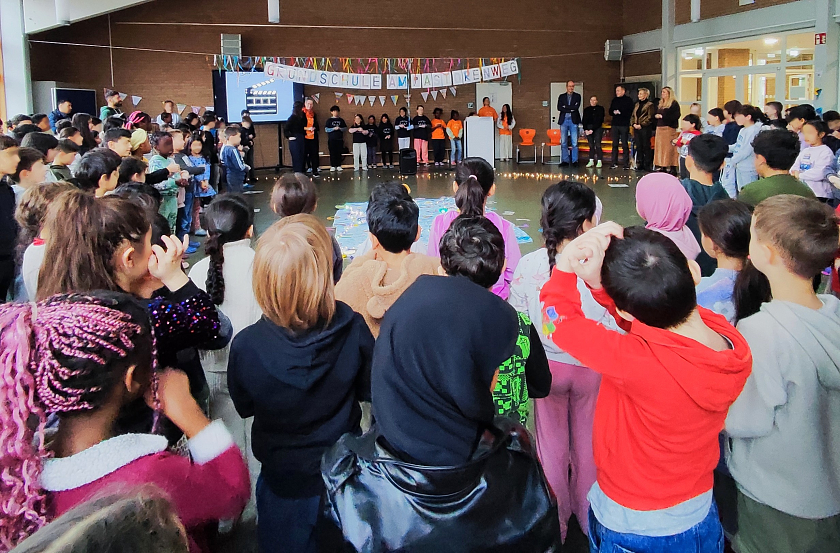 Kinder sitzen im Kreis und singen. 