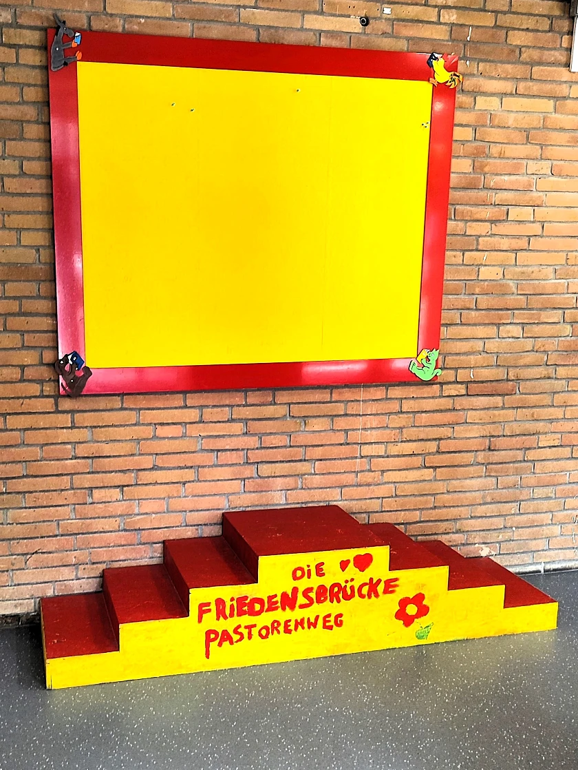 gelb-rote Friedenstreppe vor einer Mauer