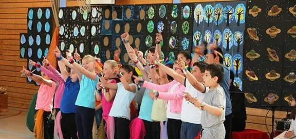 Kindergruppe hebt die Hände