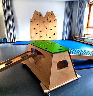 Psychomotorikraum mit blauen Bodenmatten, Kletterwürfel aus Holz