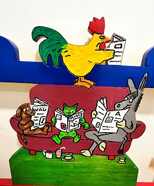 Die Bremer Stadtmusikanten sitzen auf einem braunem Sofa und lesen eine Zeitung