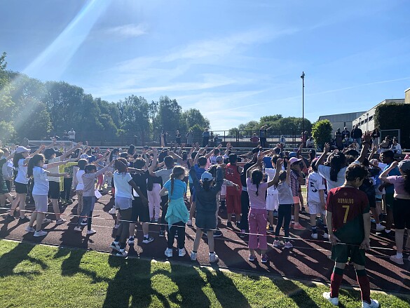 Schulkinder wärmen sich für das Sportfest auf.