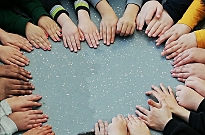 Kinderhände formen einen Kreis auf der Tischplatte